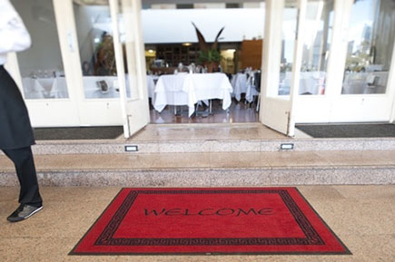 A resturant entrace with a red welcome mat