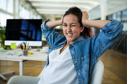 Woman experiencing headache in workplace.